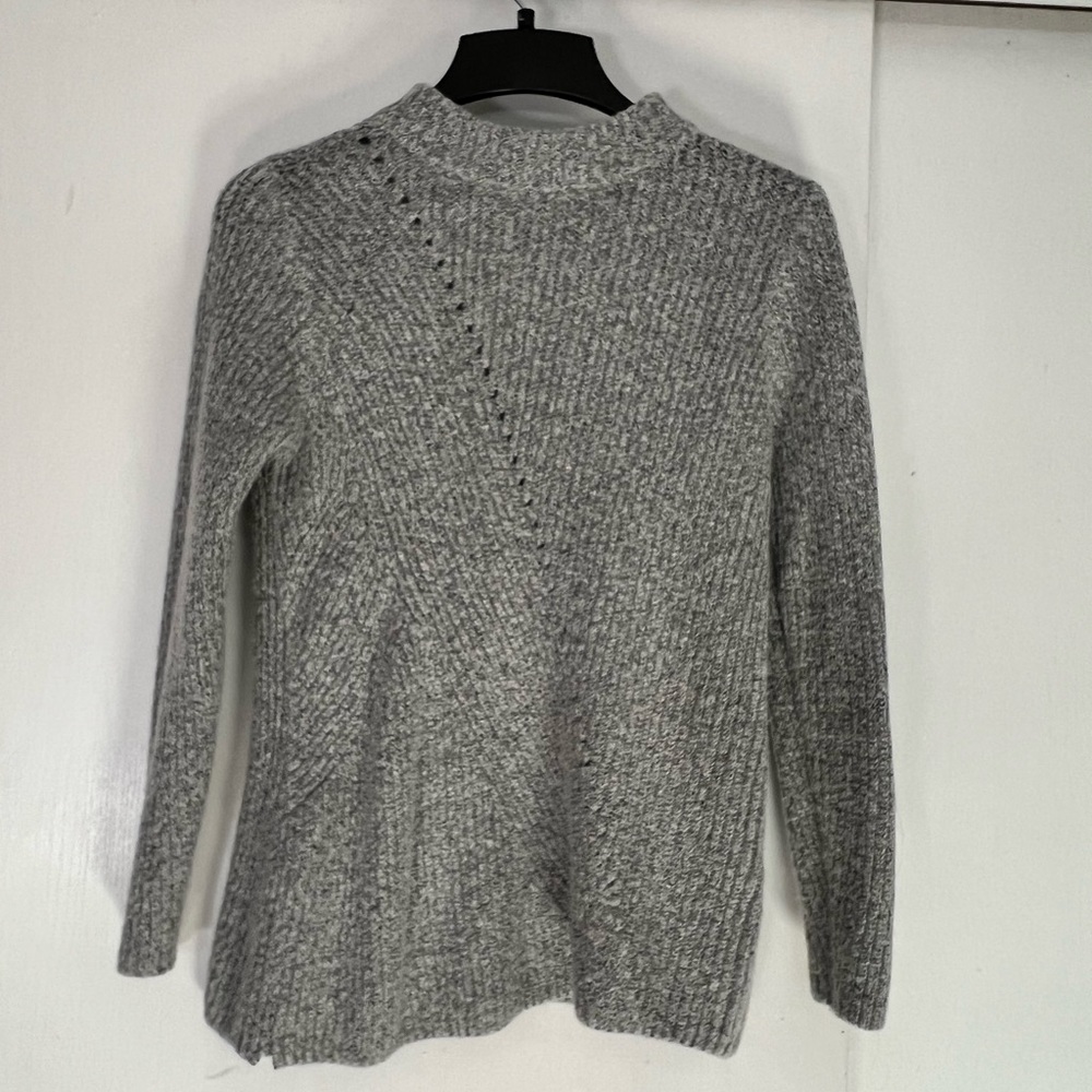 Light grey knitted sweater. It has a slight turtle neck. Brand is Carolyn Taylor